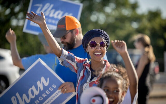 U.S. Rep. Ilhan Omar waves to passersby for support during a voter engagement event on the corner of Broadway and Central Avenues in Minneapolis, on Tuesday, Aug. 9, 2022. (Elizabeth Flores/Star Tribune via AP)