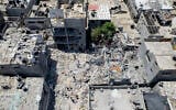 Palestinians search through the rubble of a building in which Khaled Mansour, a top Islamic Jihad militant, was killed in an Israeli airstrike on Sunday, in Rafah, southern Gaza Strip, August 8, 2022. (AP Photo/Hatem Moussa, File)
