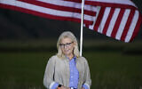 Liz Cheney, a Republican Congresswoman from Wyoming, stands by flags as she waits to speak at a primaries day gathering, Jackson, Wyoming, August 16, 2022. (AP/Jae C. Hong)