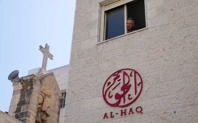 A man looks out of the window of the office of al-Haq Human rights organization that is adjacent to the St. Andrew's Anglican Episcopal Church, in the West Bank city of Ramallah, August 18, 2022. (AP Photo/Nasser Nasser) A man looks out of the window of the office of al-Haq Human rights organization that is adjacent to the St. Andrew's Anglican Episcopal Church, in the West Bank city of Ramallah, August 18, 2022. (AP Photo/Nasser Nasser)