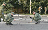 Investigators work on the site of explosion of a car driven by Daria Dugina outside Moscow, August 21, 2022. (Investigative Committee of Russia via AP)