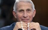 Dr. Anthony Fauci holds his face mask in his hands, as he attends a House Committee on Appropriations subcommittee hearing on about the budget request for the National Institutes of Health, May 11, 2022, on Capitol Hill in Washington. (AP/Jacquelyn Martin)