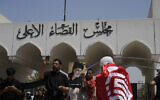 Supporters of Iraqi Shiite cleric Muqtada al-Sadr, seen in poster, protest in front the Supreme Judicial Council, in Baghdad, Iraq, Aug. 23, 2022. (Hadi Mizban/AP)