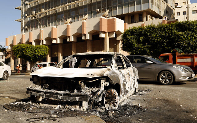 The remains of a car damaged in deadly clashes between militias backed by two rival administrations in the Libyan capital of Tripoli, August 28 2022. (AP/Yousef Murad) The remains of a car damaged in deadly clashes between militias backed by two rival administrations in the Libyan capital of Tripoli, August 28 2022. (AP/Yousef Murad)