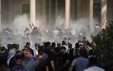 Iraqi security forces fire tear gas on the followers of Shiite cleric Muqtada al-Sadr inside the government Palace, Baghdad, Iraq, Aug. 29, 2022 (AP Photo/Hadi Mizban)