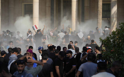 Iraqi security forces fire tear gas on the followers of Shiite cleric Muqtada al-Sadr inside the government Palace, Baghdad, Iraq, Aug. 29, 2022 (AP Photo/Hadi Mizban)