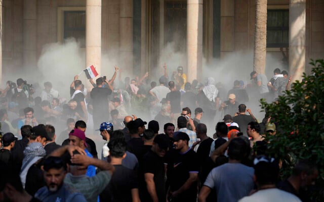 Iraqi security forces fire tear gas on the followers of Shiite cleric Muqtada al-Sadr inside the government Palace, Baghdad, Iraq, Aug. 29, 2022 (AP Photo/Hadi Mizban) Iraqi security forces fire tear gas on the followers of Shiite cleric Muqtada al-Sadr inside the government Palace, Baghdad, Iraq, Aug. 29, 2022 (AP Photo/Hadi Mizban)