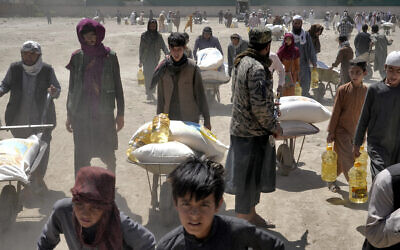 A Taliban fighter stands guard as people receive food rations distributed by a Chinese humanitarian aid group, in Kabul, Afghanistan, April 30, 2022. (Ebrahim Noroozi/AP) A Taliban fighter stands guard as people receive food rations distributed by a Chinese humanitarian aid group, in Kabul, Afghanistan, April 30, 2022. (Ebrahim Noroozi/AP)