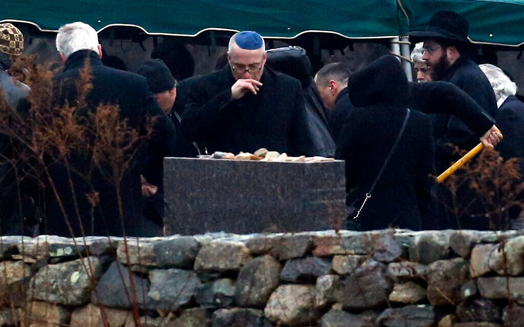 A man, center, reacts while others shovel dirt onto the grave of Noah Pozner, a six-year-old killed in the Sandy Hook Elementary School shooting who was laid to rest at B'nai Israel Cemetery, December 17, 2012, in Monroe, Connecticut. (AP Photo/Julio Cortez)