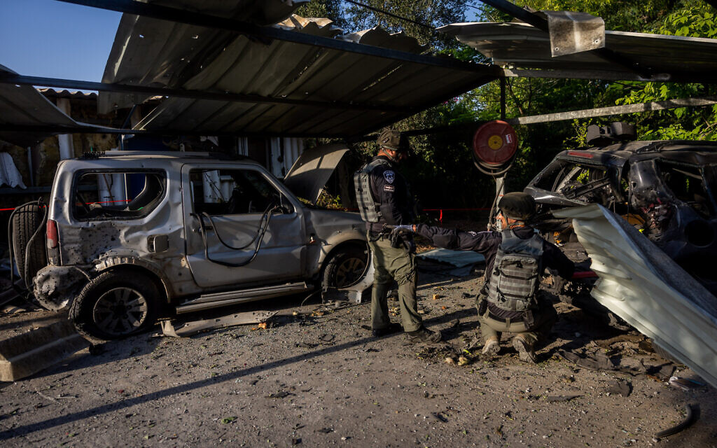 Israelis survey damage caused to a house and the surrounding area by a rocket fired from the Gaza Strip in a town near the Gaza border on August 7, 2022. (Photo by Yonatan Sindel/Flash90)