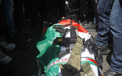 Palestinian mourners and gunmen surround the body of Mohammed Arashi, 25, during his funeral in the West Bank city of Nablus on August 23, 2022. (Nasser Ishtayeh/Flash90)