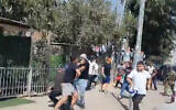 A man carrying an Israeli flag is assaulted by a group carrying Palestinian flags, near Nebi Samuel on the outskirts of Jerusalem, August 26, 2022. (Screenshot: Twitter)