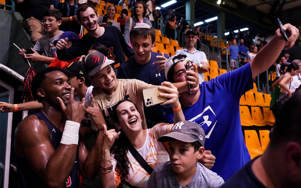 Chris Moore, left, a forward for Auburn University's basketball team, takes a selfie with fans during a game against the Israeli national under-20 basketball squad, in Malha Arena, Jerusalem, August 2, 2022. (Steven Leonard/Auburn University) Chris Moore, left, a forward for Auburn University's basketball team, takes a selfie with fans during a game against the Israeli national under-20 basketball squad, in Malha Arena, Jerusalem, August 2, 2022. (Steven Leonard/Auburn University)