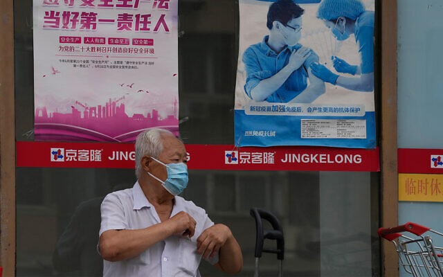 Illustrative: A man near a poster promoting vaccination in Beijing, China, July 19, 2022. (AP Photo/Ng Han Guan) Illustrative: A man near a poster promoting vaccination in Beijing, China, July 19, 2022. (AP Photo/Ng Han Guan)