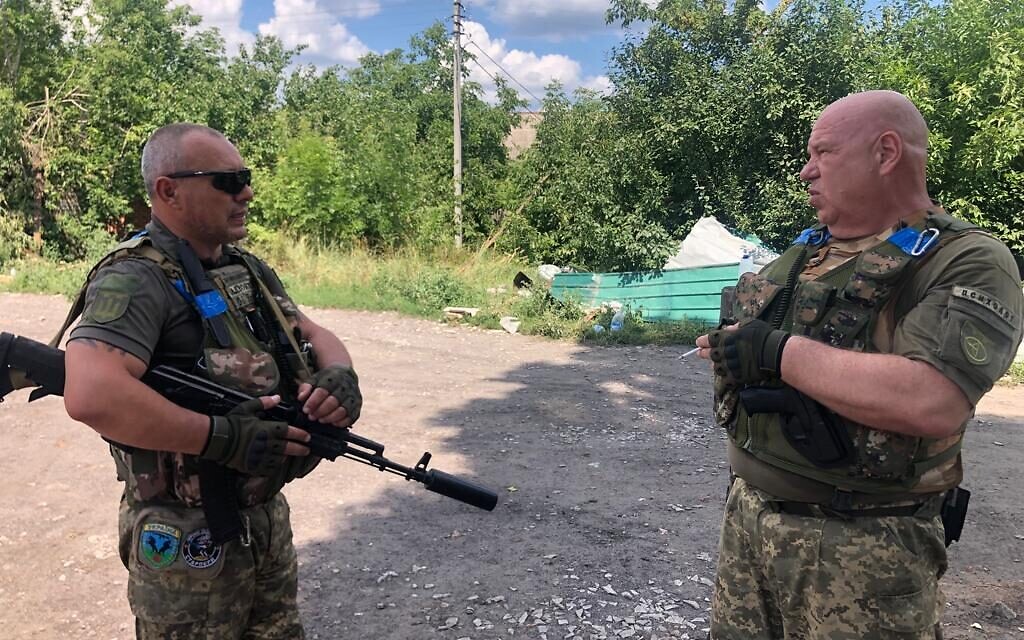 Oleksander (L) and Volodymyr, officers in the Territorial Defense Force's 128th Battalion, speak in Chuhuiv, July 28. 2022. (Lazar Berman/The Times of Israel)