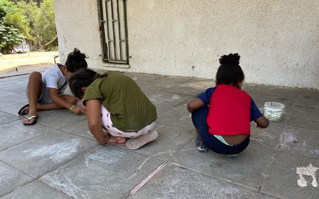 Children playing outside an apartment building in Ashkelon, during Operation Breaking Dawn, August 7, 2022. (Carrie Keller-Lynn / The Times of Israel)