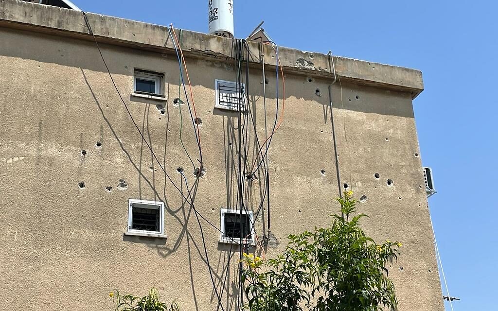 Shrapnel scarring on an apartment building in Ashkelon, after the neighboring building absorbed a lethal direct hit in 2018, August 7, 2022. (Carrie Keller-Lynn  / The Times of Israel)