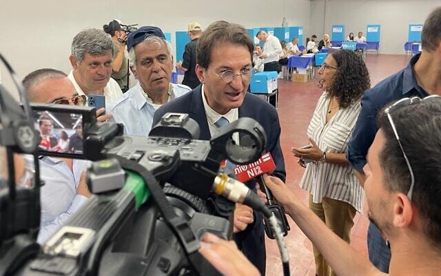 Likud candidate Boaz Bismuth speaks to the media at the party's primary polling station in Tel Aviv, August 10, 2022 (Carrie Keller-Lynn / The Times of Israel)