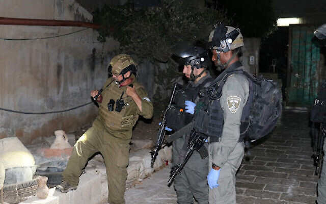 Israeli forces examine stolen antiquities recovered during an arrest operation in the West Bank on August 15, 2022. (Coordinator of Government Activities in the Territories) Israeli forces examine stolen antiquities recovered during an arrest operation in the West Bank on August 15, 2022. (Coordinator of Government Activities in the Territories)