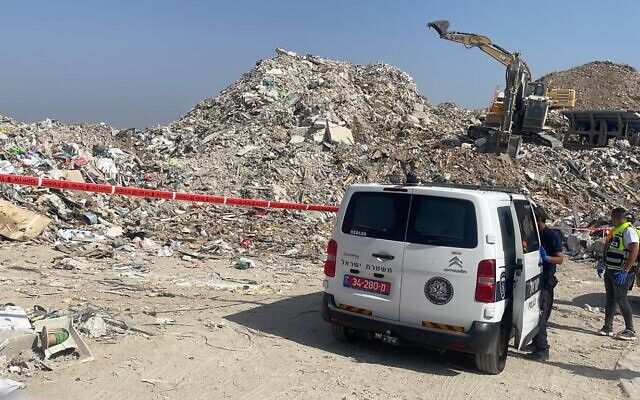 Police officers are seen at the scene of a deadly incident at a Rishon Lezion landfill, where a 40-year-old Palestinian worker was crushed to death by an excavator, August 29, 2022. (Israel Police)