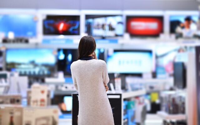 A woman looking at televisions in a store. (Filipovic018 at iStock, Getty Images)