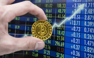 A golden bitcoin coin in front of a stock exchange chart (Getty Images)