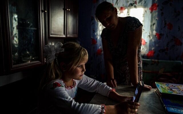 Antonina (l), 9, attends an online lesson on the first day of school at her home in the village of Pokrovske, Ukraine on September 1, 2022. (Photo by Dimitar Dilkoff / AFP) Antonina (l), 9, attends an online lesson on the first day of school at her home in the village of Pokrovske, Ukraine on September 1, 2022. (Photo by Dimitar Dilkoff / AFP)