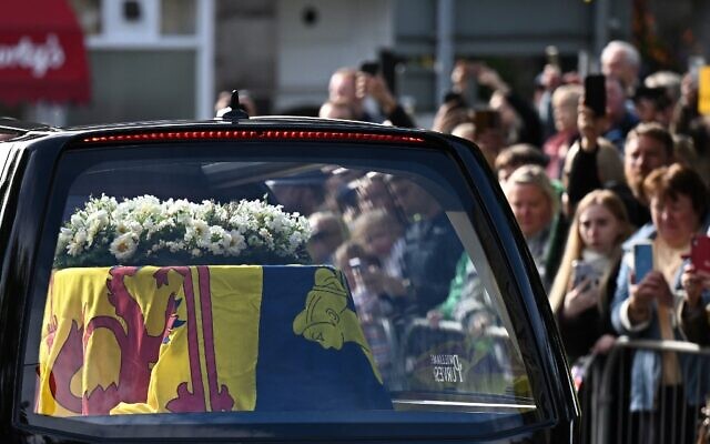 Members of the public pay their respects as they hearse carrying the coffin of Queen Elizabeth II, draped in the Royal Standard of Scotland, is driven through Ballater, on September 11, 2022. (Paul ELLIS / AFP) Members of the public pay their respects as they hearse carrying the coffin of Queen Elizabeth II, draped in the Royal Standard of Scotland, is driven through Ballater, on September 11, 2022. (Paul ELLIS / AFP)