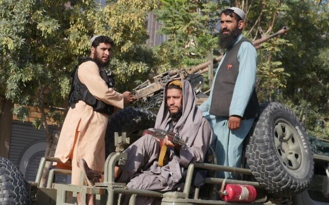 Taliban fighters stand on the back of a vehicle as they conduct a 'house to house' inspection in Herat, on September 11, 2022. (Mohsen Karimi / AFP) Taliban fighters stand on the back of a vehicle as they conduct a 'house to house' inspection in Herat, on September 11, 2022. (Mohsen Karimi / AFP)