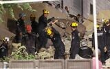 Jordanian rescue workers search for missing persons under the rubble of a four-story residential building that collapsed in central Amman, on September 13, 2022. (Khalil MAZRAAWI / AFP)