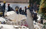 Jordanian rescue teams search for people still missing under the rubble of a collapsed four-story building in the capital Amman on September 14, 2022. (Khalil Mazraawi/AFP)