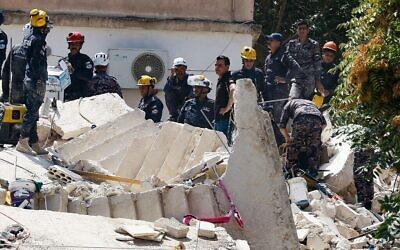Jordanian rescue teams search for people still missing under the rubble of a collapsed four-story building in the capital Amman on September 14, 2022. (Khalil Mazraawi/AFP)