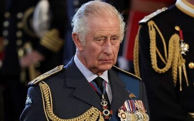 Britain's King Charles III reacts as the coffin of Queen Elizabeth II, adorned with a Royal Standard and the Imperial State Crown and pulled by a Gun Carriage of The King's Troop Royal Horse Artillery, arrives at the Palace of Westminster, following a procession from Buckingham Palace, in London on September 14, 2022. (ALKIS KONSTANTINIDIS / POOL / AFP)