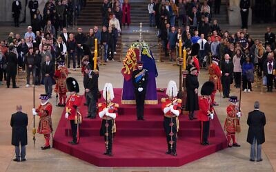 Queen Elizabeth II 's grandchildren (clockwise from front centre) Britain's Prince William, Prince of Wales, Peter Phillips, James, Viscount Severn, Britain's Princess Eugenie of York, Britain's Prince Harry, Duke of Sussex, Britain's Princess Beatrice of York, Britain's Lady Louise Windsor and Zara Tindall hold a vigil around the coffin of Queen Elizabeth II, draped in the Royal Standard with the Imperial State Crown and the Sovereign's orb and sceptre, lying in state on the catafalque in Westminster Hall, at the Palace of Westminster in London on September 16, 2022. (Aaron Chown/Pool/AFP)