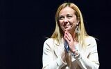 Brothers of Italy party leader Giorgia Meloni acknowledges applause after she delivered a speech on stage on September 22, 2022. (Alberto Pizzoli/AFP)
