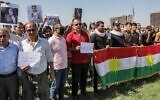 People gather with Kurdish flags during a demonstration denouncing the death of 22-year-old Mahsa Amini -- who died while in the custody of Iranian authorities -- by Iraqi and Iranian Kurds outside the UN offices in Erbil, the capital of Iraq's autonomous Kurdistan region, on September 24, 2022. (SAFIN HAMED / AFP)
