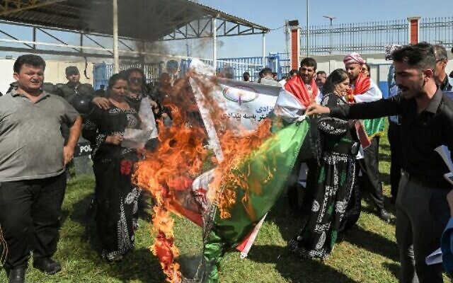 People burn an Iranian national flag during a demonstration denouncing the death of 22-year-old Mahsa Amini -- who died while in the custody of Iranian authorities -- by Iraqi and Iranian Kurds outside the UN offices in Arbil, the capital of Iraq's autonomous Kurdistan region, on September 24, 2022. (Safin Hamed/AFP) People burn an Iranian national flag during a demonstration denouncing the death of 22-year-old Mahsa Amini -- who died while in the custody of Iranian authorities -- by Iraqi and Iranian Kurds outside the UN offices in Arbil, the capital of Iraq's autonomous Kurdistan region, on September 24, 2022. (Safin Hamed/AFP)