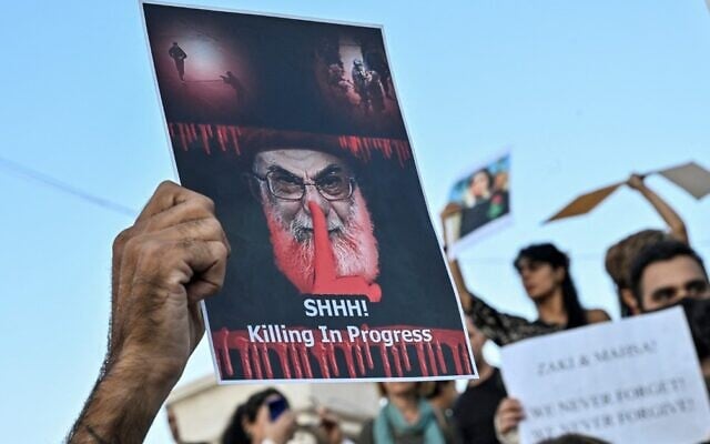 Illustrative: A protester holds a placard depicting Iran's Supreme Leader Ayatollah Ali Khamenei during a demonstration in Athens by Iranians living in Greece, September 24, 2022, following the death of an Iranian woman after her arrest by the country's morality police in Tehran. (Louisa Gouliamaki/AFP) Illustrative: A protester holds a placard depicting Iran's Supreme Leader Ayatollah Ali Khamenei during a demonstration in Athens by Iranians living in Greece, September 24, 2022, following the death of an Iranian woman after her arrest by the country's morality police in Tehran. (Louisa Gouliamaki/AFP)