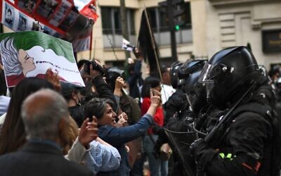 People face riot police as they take part in a demonstration in support of Iranian protesters in Paris, on September 25, 2022. (Christophe Archambault/AFP)