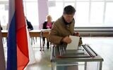 A woman casts her ballot for a referendum on joining the Russian Federation at a polling station in Mariupol, under the control of the pro-Russian Donetsk People's Republic on September 27, 2022. (STRINGER/AFP)