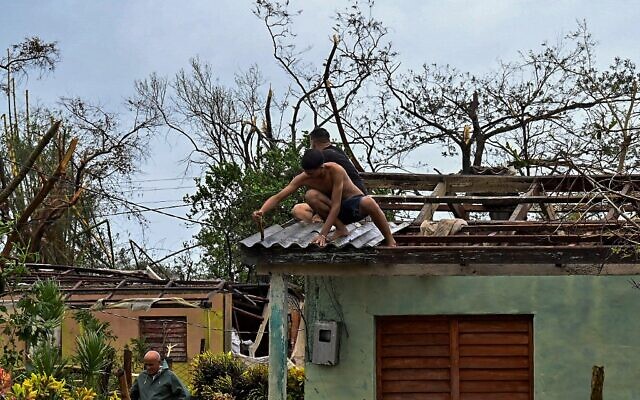 Cubans repair a roof in San Juan y Martinez, Pinar del Rio Province, on September 27, 2022 after the passage of Hurricane Ian (ADALBERTO ROQUE / AFP) Cubans repair a roof in San Juan y Martinez, Pinar del Rio Province, on September 27, 2022 after the passage of Hurricane Ian (ADALBERTO ROQUE / AFP)