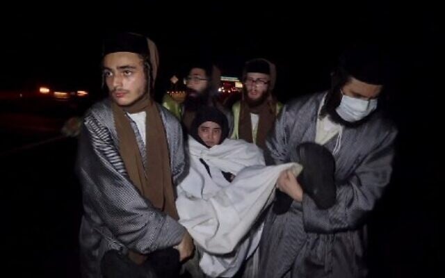 Members of the extreme ultra-Orthodox Lev Tahor sect assisting a woman as they escape from a detention shelter in Huixtla, Chiapas state, Mexico, on September 29, 2022. (Benjamin Alfaro/AFP)