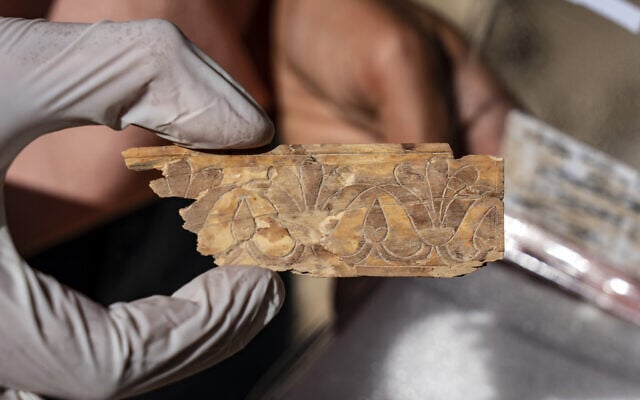 An ivory plaque decorated with a lotus flower from the First Temple period (1200-586 BCE) unearthed in excavations by the Israel Antiquities Authority and Tel Aviv University at the Givati Parking Lot in the City of David in Jerusalem, in a discovery announced on September 5, 2022. (Yaniv Berman/Israel Antiquities Authority)