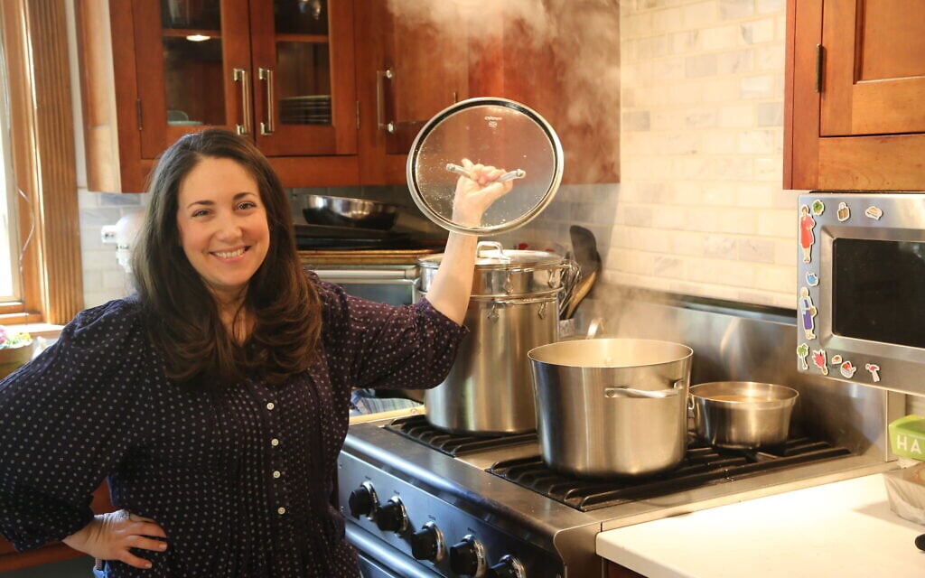 Shannon Sarna, author of 'Modern Jewish Comfort Food,' stands over a pot of chicken soup, one of the many comfort food recipes in her new book. (Doug Schneider/via JTA) Shannon Sarna, author of 'Modern Jewish Comfort Food,' stands over a pot of chicken soup, one of the many comfort food recipes in her new book. (Doug Schneider/via JTA)