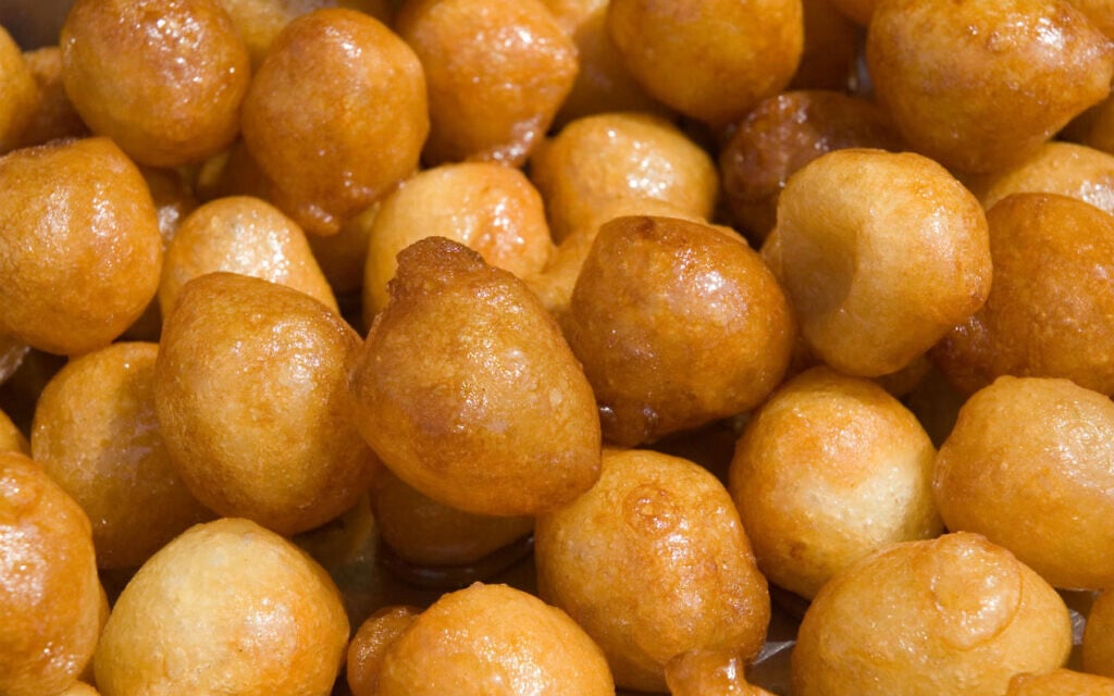 Taygalach, crunchy dough balls boiled in honeyed syrup until soaked through and sticky. (The Nosher/ JTA) Taygalach, crunchy dough balls boiled in honeyed syrup until soaked through and sticky. (The Nosher/ JTA)