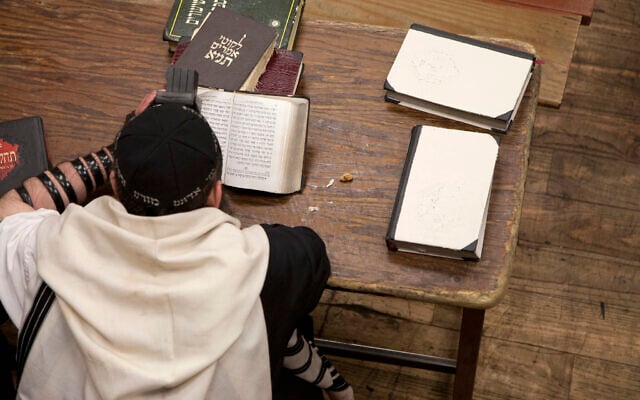Jewish man wearing tefillin and reading religious text. (Getty Images) Jewish man wearing tefillin and reading religious text. (Getty Images)