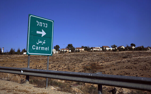 This photo from October 28, 2016, shows a road sign indicating the direction to the Israeli settlement of Carmel, southeast of the West Bank city of Hebron. (AP Photo/Nasser Shiyoukhi) This photo from October 28, 2016, shows a road sign indicating the direction to the Israeli settlement of Carmel, southeast of the West Bank city of Hebron. (AP Photo/Nasser Shiyoukhi)