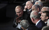 Russian President Vladimir Putin waves to Britain's Prince Charles during the World Holocaust Forum in Jerusalem on Jan. 23, 2020 (Abir Sultan/Pool Photo via AP)