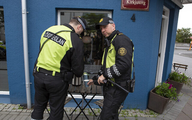 Illustrative: Two police officers help themselves to free coffee after standing guard outside the inauguration of Iceland's president Guðni Th. Jóhannesson in Reykjavik, Iceland Saturday August 1, 2020. (AP/Árni Torfason) Illustrative: Two police officers help themselves to free coffee after standing guard outside the inauguration of Iceland's president Guðni Th. Jóhannesson in Reykjavik, Iceland Saturday August 1, 2020. (AP/Árni Torfason)