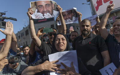Maryam Banat, 67, mother of Palestinian Authority outspoken critic Nizar Banat holds a poster with his picture while attending a rally protesting his death, in the West Bank city of Ramallah, Saturday, July 3, 2021. (AP Photo/Nasser Nasser) Maryam Banat, 67, mother of Palestinian Authority outspoken critic Nizar Banat holds a poster with his picture while attending a rally protesting his death, in the West Bank city of Ramallah, Saturday, July 3, 2021. (AP Photo/Nasser Nasser)